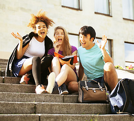 Image showing cute group of teenages at the building of university with books 