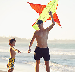 Image showing father and son, sunset at the seacoast with kite, happy family 