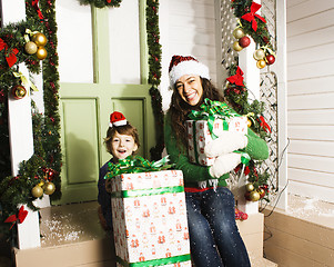 Image showing happy family on Christmas in red hats waiting gests and smiling outdoor