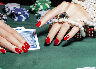 Image showing hands of young caucasian woman with red manicure at casino table