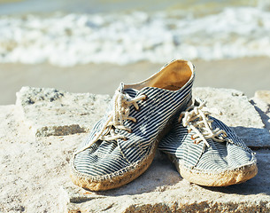 Image showing picture of vintage old shabby sneakers at seacost, real forgotte