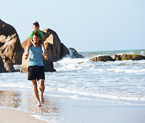 Image showing happy family on beach playing, father with son walking sea coast, rocks behind smiling enjoy summer