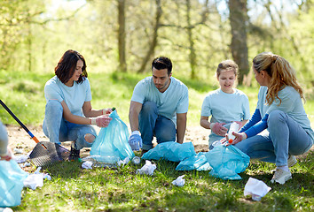 Image showing volunteers with garbage bags cleaning park area