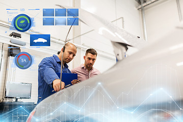 Image showing auto mechanic with clipboard and man at car shop