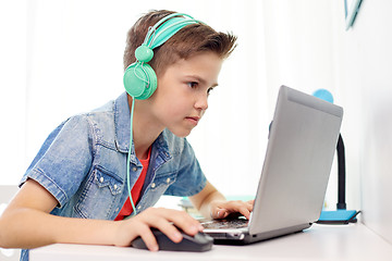 Image showing boy in headphones playing video game on laptop