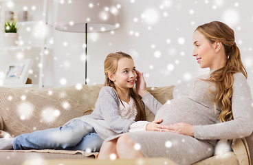 Image showing happy pregnant woman and girl on sofa at home