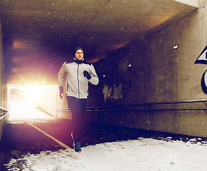 Image showing man running along subway tunnel in winter