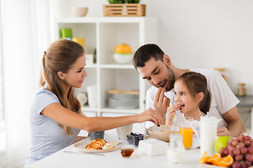 Image showing happy family having breakfast at home