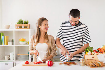 Image showing happy couple cooking food at home kitchen