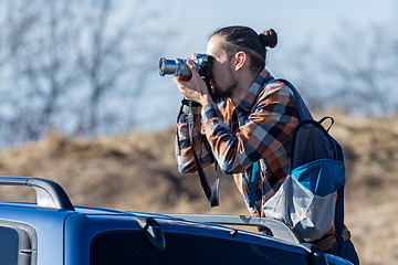 Image showing Photographer takes pictures from the car