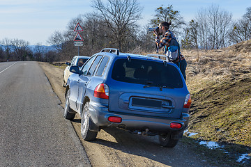 Image showing Photographer takes pictures from the car