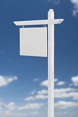 Image showing Blank Real Estate Sign Over A Blue Sky with Clouds.