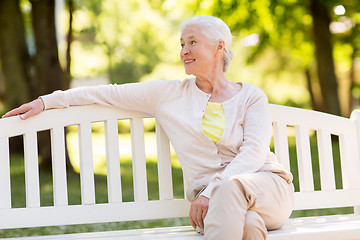 Image showing happy senior woman sitting on bench at summer park