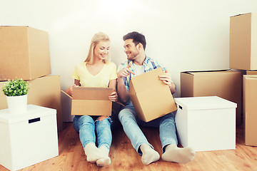 Image showing smiling couple with many boxes moving to new home