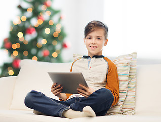 Image showing smiling boy with tablet pc at home at christmas