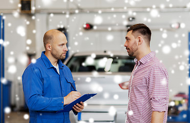 Image showing auto mechanic with clipboard and man at car shop