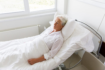 Image showing sad senior woman lying on bed at hospital ward