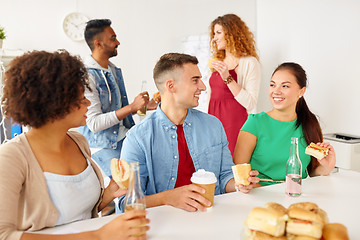 Image showing happy friends or team eating at office