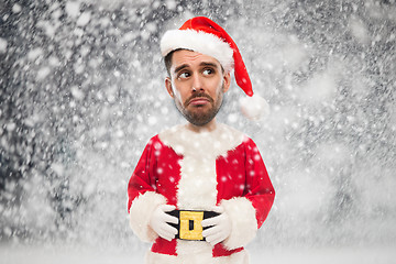 Image showing sad man in santa claus costume over christmas snow