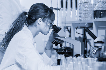 Image showing Female health care researcher microscoping in scientific laboratory.