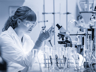 Image showing Young scientist pipetting in life science laboratory.