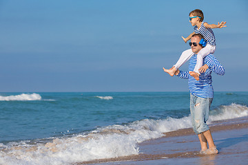 Image showing Father and son playing on the beach at the day time. Concept of 