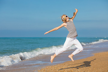 Image showing One happy little girl playing on the beach at the day time