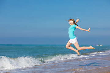 Image showing teen girl jumping on the beach at blue sea shore in summer vacat