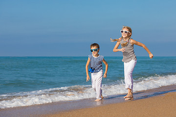 Image showing Two happy children playing on the beach at the day time