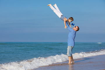 Image showing Father and son playing on the beach at the day time. Concept of 