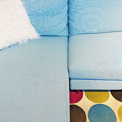 Image showing Fluffy white cushion on a blue textile sofa