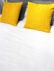 Image showing Bed with bright yellow velveteen cushions