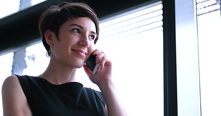 Image showing Business Girl Standing In A Modern Building Near The Window With