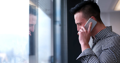 Image showing Business Man Talking On Cell Phone, Looking Out Office Window