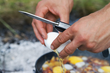 Image showing Fried eggs cooking on camp fire