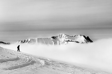 Image showing Black and white silhouette of snowboarder on off-piste slope wit