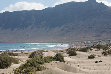 Image showing The red flag weighs in the wind at Surfers Beach Famara on Lanza