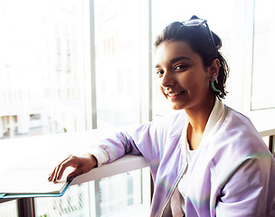 Image showing young cute hipster girl student sitting in cafe with notebook re