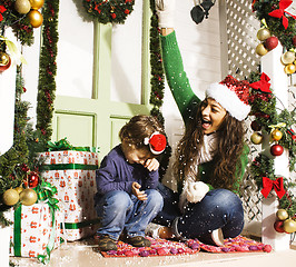 Image showing happy family on Christmas in red hats waiting gests and smiling