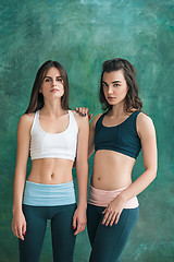 Image showing Two young sporty women posing at gym.