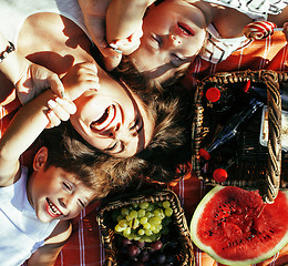 Image showing cute happy family on picnic laying on green grass mother and kids, warm summer vacations