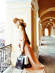 Image showing young pretty smiling woman in hat with bags on shopping at store