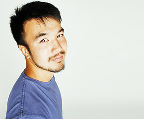 Image showing young cute asian man on white background gesturing emotional, po