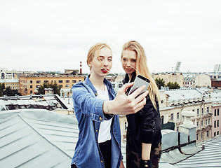 Image showing two cool blond real girls friends making selfie on roof top, lif