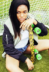 Image showing cool pretty smiling afro-american happy young woman with skate b