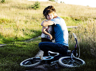 Image showing father learning his son to ride on bicycle outside, real happy f