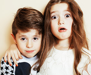 Image showing little cute boy and girl hugging playing on white background, happy family smiling brother and sister fooling around, lifestyle people concept