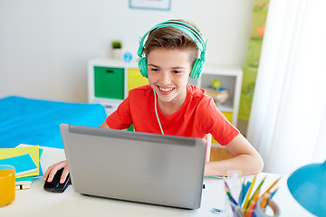 Image showing boy in headphones playing video game on laptop