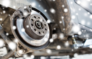 Image showing car brake disc at repair station over snow