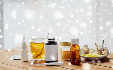 Image showing drugs, thermometer, honey and cup of tea on wood